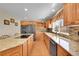 The kitchen boasts granite countertops, stainless steel appliances, wooden cabinets, and natural light from the window at 8167 S Dover St, Littleton, CO 80128