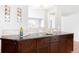 Stylish kitchen featuring dark countertops, tiled backsplash, and wooden cabinets with decorative metal accents at 2756 E Euclid Ave, Centennial, CO 80121
