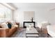 Bright living room featuring a leather sofa, two white armchairs, and modern decor at 2756 E Euclid Ave, Centennial, CO 80121