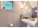 Bathroom featuring a pedestal sink, decorative mirror, and modern lighting fixtures at 35 Elati St, Denver, CO 80223