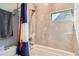 Bathroom with tiled shower featuring a rainfall showerhead and a niche, plus bathtub with colorado flag at 35 Elati St, Denver, CO 80223