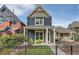 Charming two-story home with a quaint front porch and green chairs, set behind a black metal fence at 35 Elati St, Denver, CO 80223