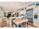 Bright open kitchen with island seating, stainless appliances, and seamless flow to the dining and living areas at 35 Elati St, Denver, CO 80223