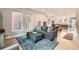 Cozy living room with a plush gray sectional, light wood floors and an open layout to the dining area at 35 Elati St, Denver, CO 80223