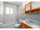 Simple bathroom with a tub, toilet, and vanity at 5493 Quari St, Denver, CO 80239