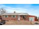 Brick ranch home with attached garage and landscaped yard at 5493 Quari St, Denver, CO 80239