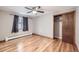 Spacious bedroom with wood floors, a ceiling fan, and sliding closet doors at 1824 S Columbine St, Denver, CO 80210