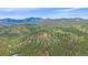 Aerial view of a home nestled amongst dense trees on a beautiful wooded lot at 31231 Red Hawk Trl, Conifer, CO 80433