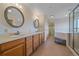 Well-lit bathroom with double sink vanity, ample storage, and a separate shower and tub area at 31231 Red Hawk Trl, Conifer, CO 80433