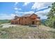Charming exterior elevation showcasing a two-car garage, beautiful entryway, and meticulously kept landscaping at 31231 Red Hawk Trl, Conifer, CO 80433