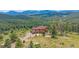 Beautiful aerial view showcasing lush forestry, mountain views, and the home with a two-car garage at 31231 Red Hawk Trl, Conifer, CO 80433