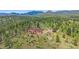 Exterior angle shot of a large, beautiful home on a hill with mature trees at 31231 Red Hawk Trl, Conifer, CO 80433