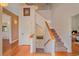 Inviting hallway featuring hardwood floors, a staircase with carpet, and a combination of white and neutral walls at 31231 Red Hawk Trl, Conifer, CO 80433