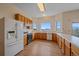 Bright kitchen with wood cabinets, white appliances, laminate floors, and expansive mountain view window at 31231 Red Hawk Trl, Conifer, CO 80433