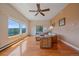 Bright living room with hardwood floors, ceiling fan, and scenic mountain views from large windows at 31231 Red Hawk Trl, Conifer, CO 80433