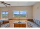 Cozy living room with hardwood floors, natural light, and stunning mountain views from expansive windows at 31231 Red Hawk Trl, Conifer, CO 80433