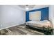 Bedroom featuring wood floors, blue accent wall, and a bed at 5789 S Jay St, Littleton, CO 80123