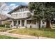 Charming home with a well-manicured lawn, mature tree, and inviting front porch at 1401 S Clarkson St, Denver, CO 80210