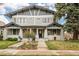 Charming gray two-story home featuring a well-maintained lawn, inviting entrance and welcoming front porch at 1401 S Clarkson St, Denver, CO 80210