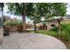 Beautiful backyard with a paved patio, pergola, mature trees, and string lights, creating a relaxing ambiance at 1308 York St, Denver, CO 80206