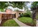 Serene backyard features a brick walkway, a pergola with climbing vines, and lush greenery at 1308 York St, Denver, CO 80206
