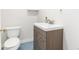 Bathroom features wood-look vanity, toilet, brushed nickel faucet and fixtures, and vinyl floor at 1308 York St, Denver, CO 80206