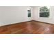 Empty bedroom with hardwood floors, white walls, and windows offering natural light at 1308 York St, Denver, CO 80206