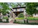 Charming brick home with mature landscaping, a covered front porch, and classic architectural details at 1308 York St, Denver, CO 80206