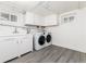 Basement laundry room features wood-look floor, modern washer and dryer, and white cabinets at 1308 York St, Denver, CO 80206