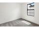 A bedroom featuring neutral carpet, white walls, and a large window with a black frame at 2036 S Holly St # 4, Denver, CO 80222