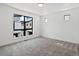 A bedroom featuring neutral carpet, white walls, and multiple windows with black frames at 2036 S Holly St # 4, Denver, CO 80222