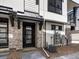 Inviting townhome entrance with stone veneer and a stylish black front door at 2036 S Holly St # 4, Denver, CO 80222