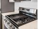 This kitchen features a stainless gas range, quartz countertops and grey cabinets at 2036 S Holly St # 4, Denver, CO 80222