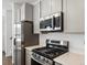 This kitchen features stainless appliances, grey cabinets, quartz countertops, and recessed lighting at 2036 S Holly St # 4, Denver, CO 80222