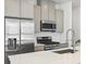 Bright kitchen with stainless steel appliances, island, and gray cabinets at 2036 S Holly St # 4, Denver, CO 80222