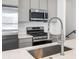 This kitchen features stainless appliances, modern cabinets, a spring faucet and quartz countertops at 2036 S Holly St # 4, Denver, CO 80222