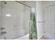Bathroom tub and shower with white tile surround and decorative curtain at 2875 Blue Sky Cir # 4-303, Erie, CO 80516