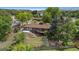 Aerial view showcases the home, lush backyard, deck, and patio surrounded by mature trees at 2180 Myrtlewood Ln, Lakewood, CO 80215