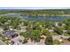 High angle shot of the home, lush surroundings, and nearby tranquil lake at 2180 Myrtlewood Ln, Lakewood, CO 80215