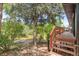 Backyard features mature trees and a wooden deck with stairs at 2180 Myrtlewood Ln, Lakewood, CO 80215