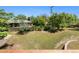 View of landscaped backyard with lush lawn, mature trees, and stone terrace from deck at 2180 Myrtlewood Ln, Lakewood, CO 80215