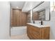 This bathroom features a dual vanity, bathtub and shower with modern wood accents at 2180 Myrtlewood Ln, Lakewood, CO 80215