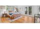 Sunlit bedroom with hardwood floors and access to a private balcony at 2180 Myrtlewood Ln, Lakewood, CO 80215