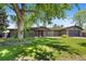 Charming home with a large tree, lush green lawn, and inviting red front door at 2180 Myrtlewood Ln, Lakewood, CO 80215