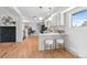 Bright updated kitchen with white cabinets, bar seating, and light-toned wood floors at 2180 Myrtlewood Ln, Lakewood, CO 80215