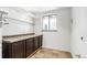 This laundry room offers ample storage space with upper shelving and lower cabinets at 2180 Myrtlewood Ln, Lakewood, CO 80215