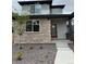 Charming two-story home featuring stone accents, a red front door, and a neatly landscaped front yard at 21031 E 63Rd Dr, Aurora, CO 80019