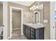 Well-lit bathroom with a dark vanity, a sink with a large mirror, and a closet for ample storage at 1677 Valley Oak Ct, Castle Rock, CO 80104