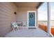 Close up of the front porch with a table and two chairs beside the blue front door with a wreath at 1677 Valley Oak Ct, Castle Rock, CO 80104