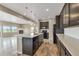 Open concept kitchen with dark cabinetry, a spacious island, and seamless flow to the living area at 1677 Valley Oak Ct, Castle Rock, CO 80104